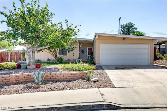 ranch-style house featuring fence, driveway, and an attached garage