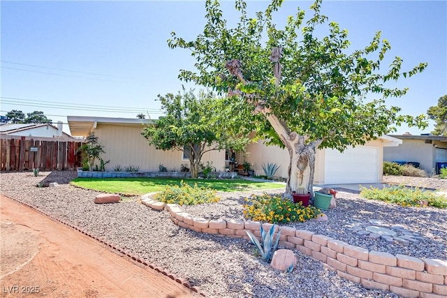 view of front facade with a front yard, concrete driveway, fence, and an attached garage