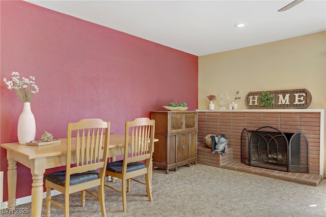 dining room featuring carpet flooring and a brick fireplace