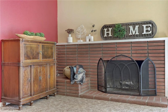 room details featuring carpet and a brick fireplace