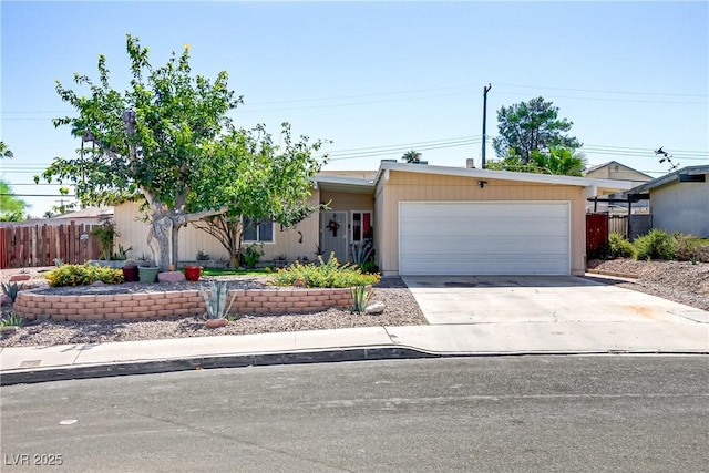 single story home featuring concrete driveway, an attached garage, and fence