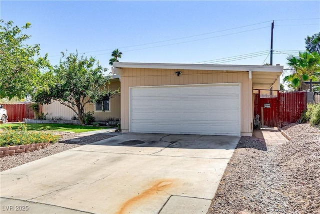 garage with fence and driveway