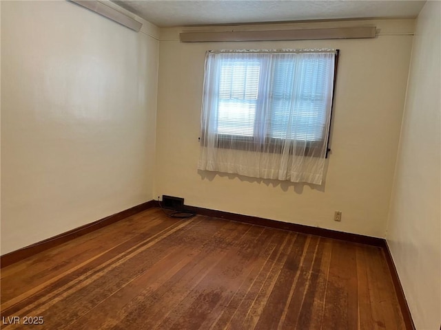 empty room featuring baseboards and wood finished floors