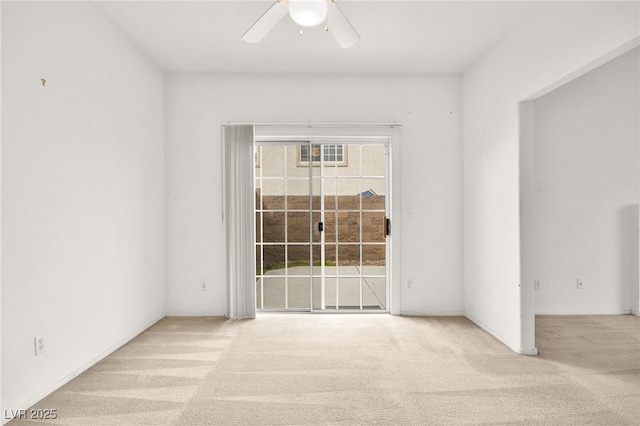 spare room featuring a ceiling fan and light carpet