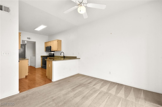 kitchen with visible vents, dark countertops, stainless steel appliances, light brown cabinetry, and a sink