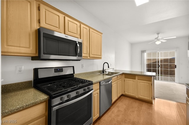 kitchen with light wood finished floors, light brown cabinetry, appliances with stainless steel finishes, a ceiling fan, and a sink