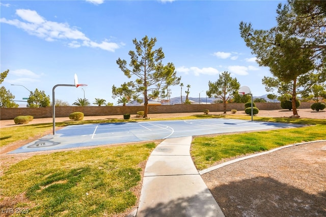 view of sport court featuring community basketball court, fence, and a yard