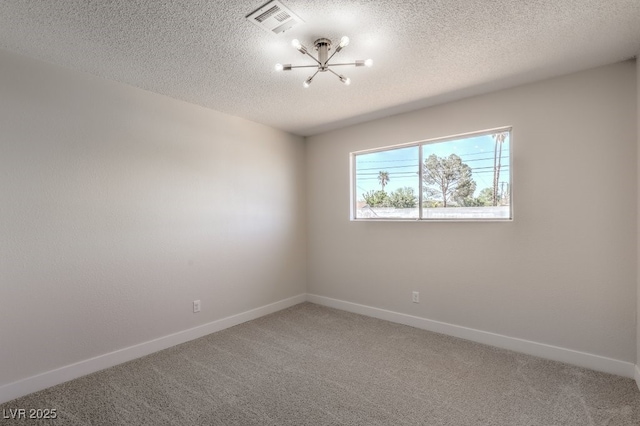 carpeted empty room featuring a notable chandelier, baseboards, visible vents, and a textured ceiling