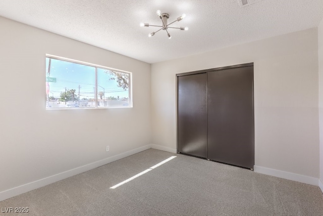 unfurnished bedroom featuring a textured ceiling, baseboards, and carpet flooring