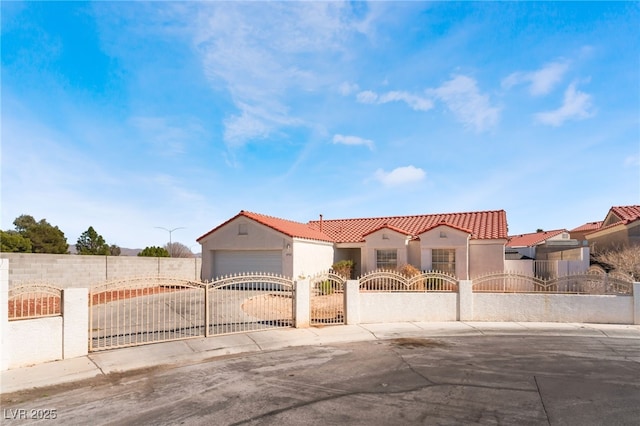 mediterranean / spanish-style house featuring a fenced front yard, driveway, and stucco siding