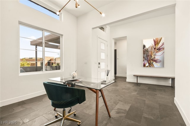 office space featuring an inviting chandelier, visible vents, and baseboards