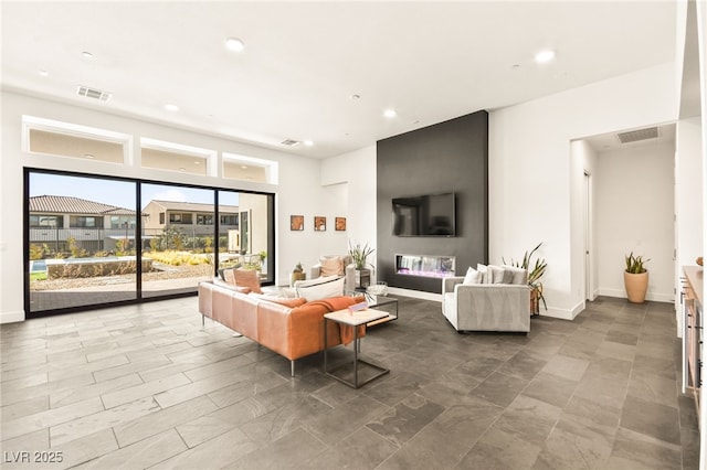 living room featuring baseboards, visible vents, and recessed lighting