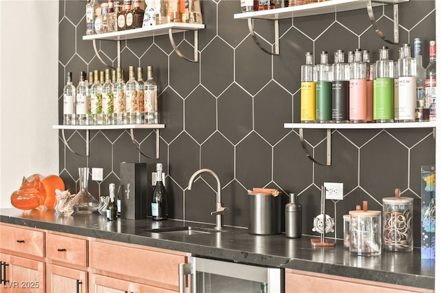 bar with beverage cooler, a bar, tasteful backsplash, and a sink