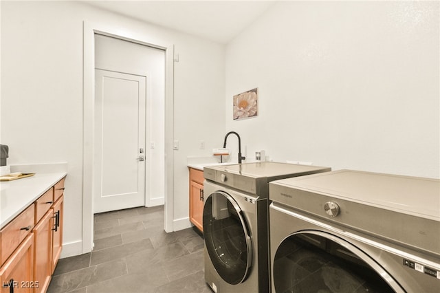 laundry area featuring separate washer and dryer, a sink, and baseboards