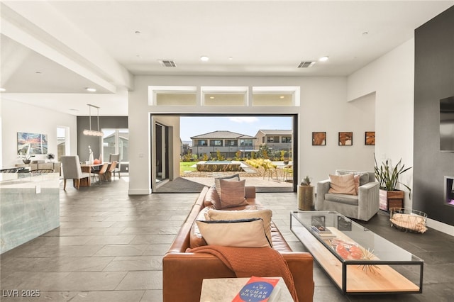 living area featuring a fireplace, visible vents, and baseboards