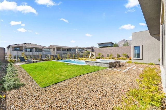 view of yard with a fenced backyard, a residential view, an outdoor hot tub, and a fenced in pool