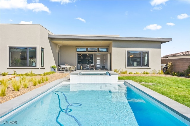 back of property featuring an outdoor pool, a lawn, a patio, an in ground hot tub, and stucco siding