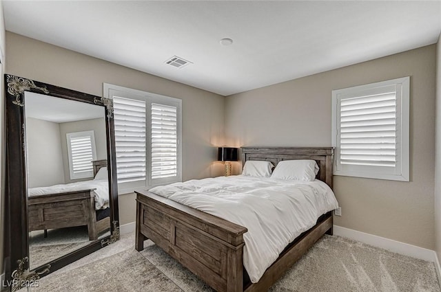carpeted bedroom featuring visible vents and baseboards
