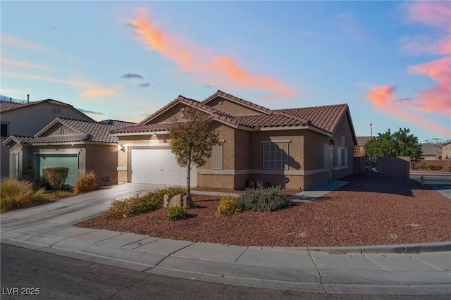 view of front of home with driveway, a tiled roof, an attached garage, and stucco siding