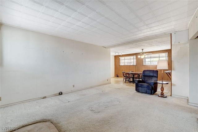 living area featuring light carpet and baseboards