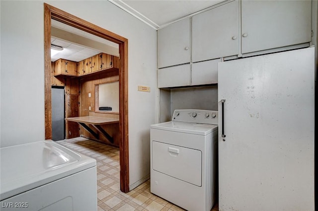 washroom with light floors and washer and clothes dryer