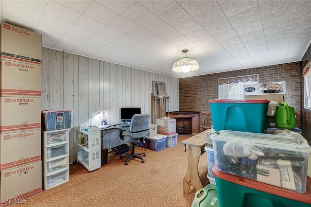 office with brick wall and carpet flooring