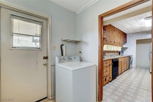 laundry area featuring a sink, washer / dryer, laundry area, and light floors