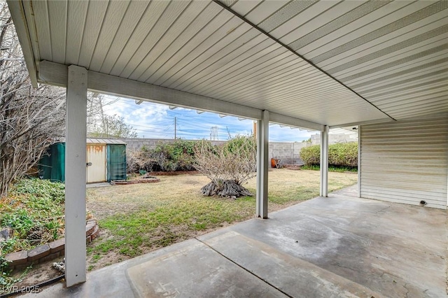 view of patio featuring a storage unit, an outdoor structure, and a fenced backyard