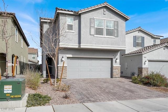 view of front of house with an attached garage, stone siding, decorative driveway, and stucco siding