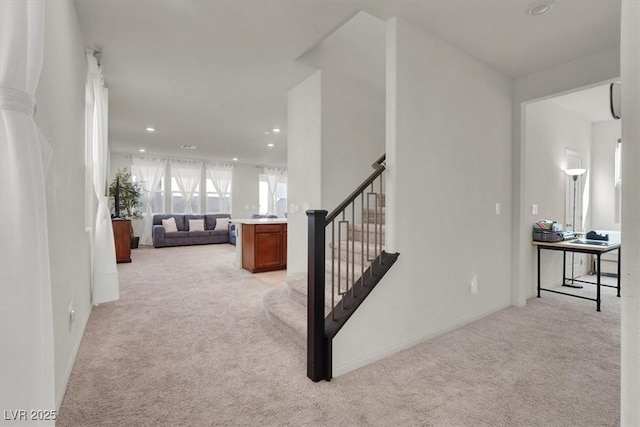 hall featuring recessed lighting, light colored carpet, and stairs