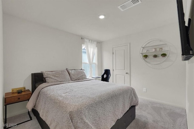 bedroom with baseboards, visible vents, and light colored carpet