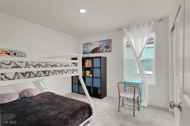 bedroom featuring light carpet and baseboards