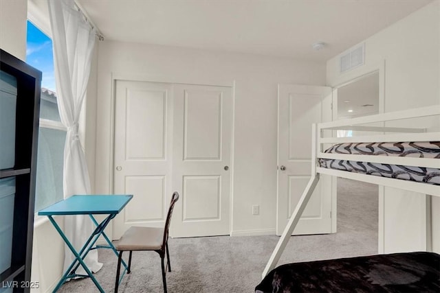 bedroom featuring light carpet, a closet, and visible vents