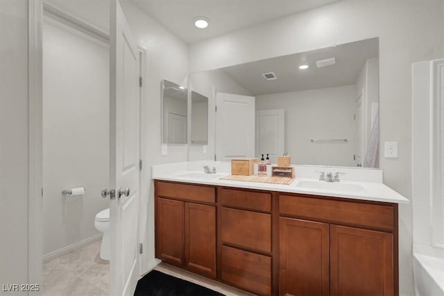 full bath featuring double vanity, visible vents, toilet, a sink, and recessed lighting