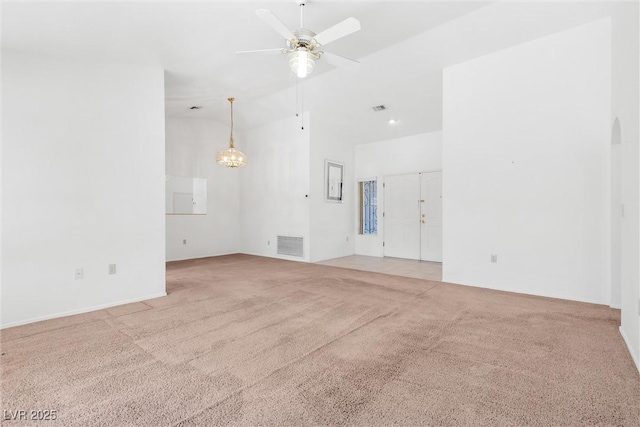 spare room featuring a ceiling fan, arched walkways, light colored carpet, and visible vents