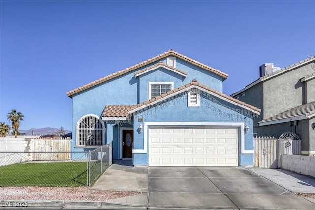 mediterranean / spanish house with a garage, fence, a tiled roof, concrete driveway, and stucco siding