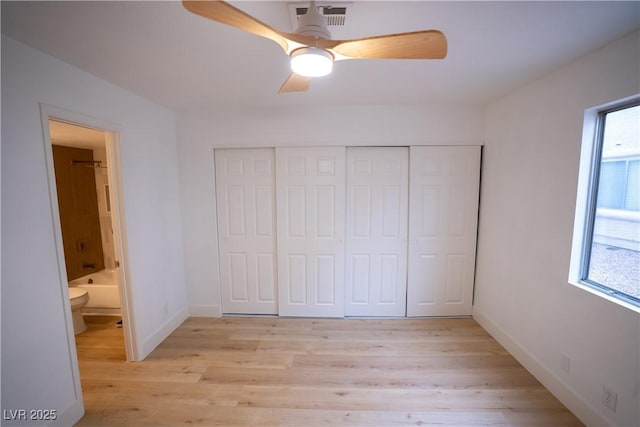 unfurnished bedroom featuring light wood-type flooring, multiple windows, and a closet