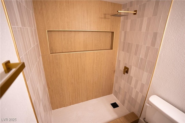 bathroom with tiled shower and toilet