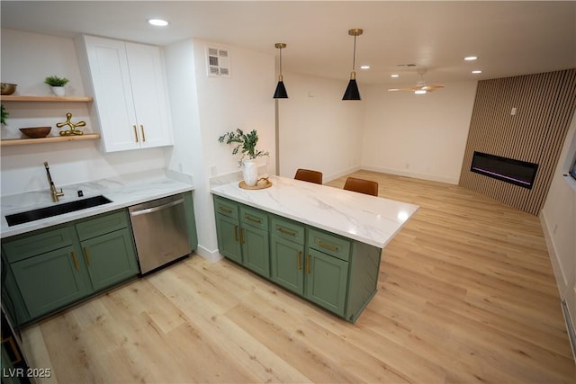 kitchen with open shelves, stainless steel dishwasher, a sink, green cabinetry, and a peninsula