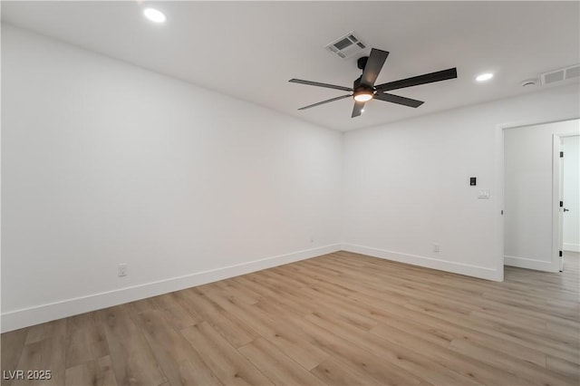 spare room featuring baseboards, visible vents, and light wood-style floors