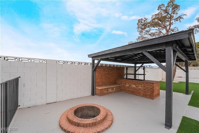 view of patio featuring fence, a fire pit, and a gazebo