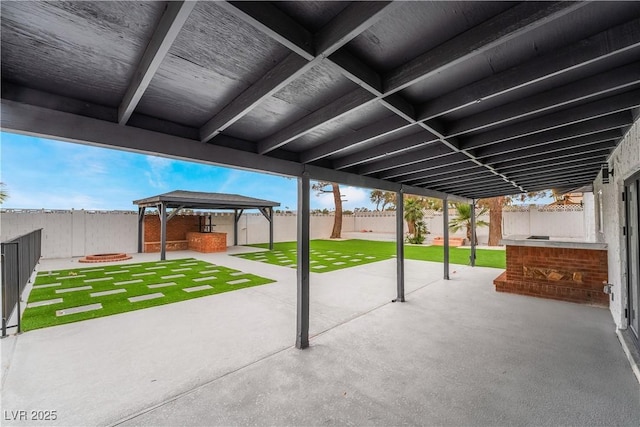 view of patio featuring a fenced backyard, a fire pit, and a gazebo