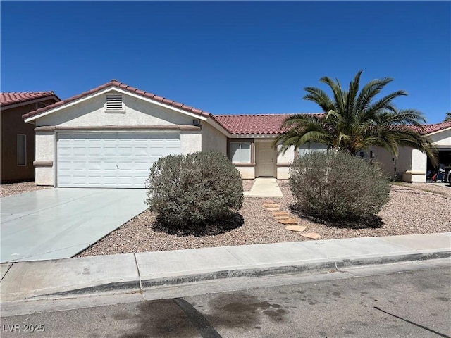 view of front of home with a garage, driveway, a tile roof, and stucco siding