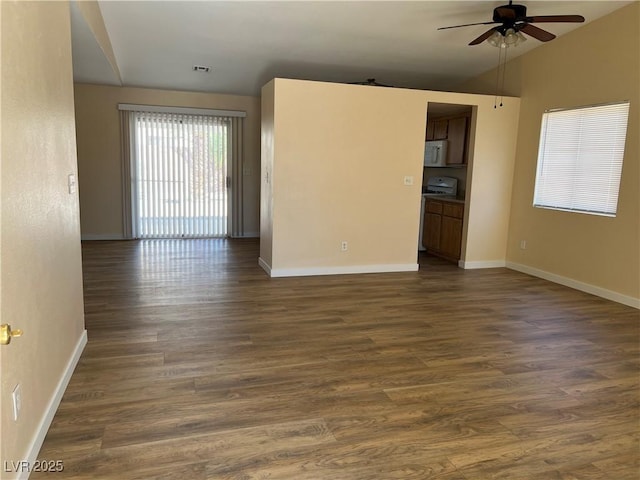 empty room with vaulted ceiling, dark wood-style flooring, a ceiling fan, and baseboards