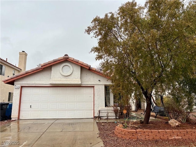 view of front of property with an attached garage, driveway, a tile roof, and stucco siding