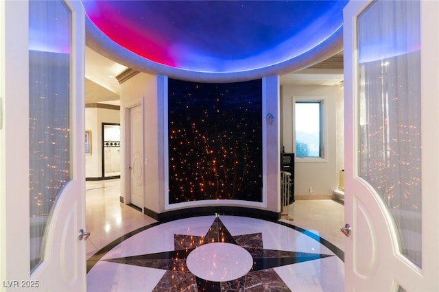 bathroom with marble finish floor, a raised ceiling, and baseboards