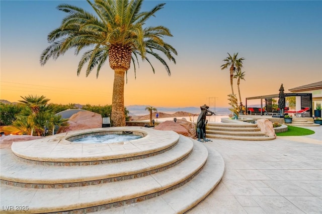 view of community with a gazebo, a patio area, and a hot tub