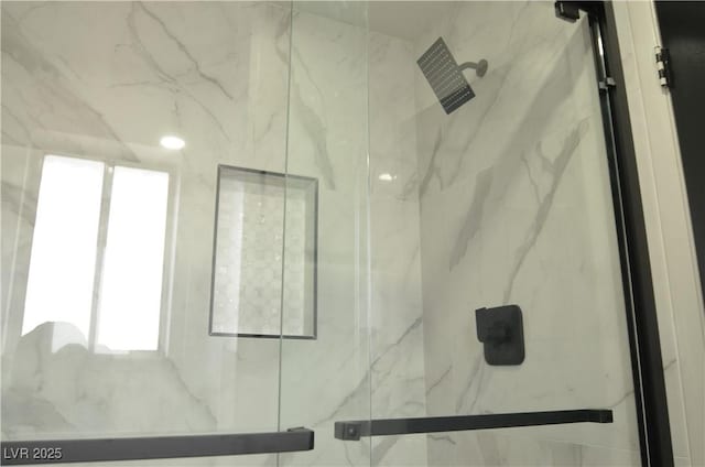 interior details featuring a marble finish shower