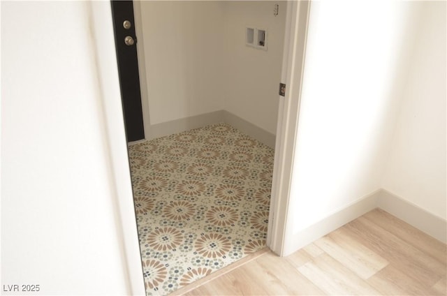 hall featuring light wood-style floors and baseboards