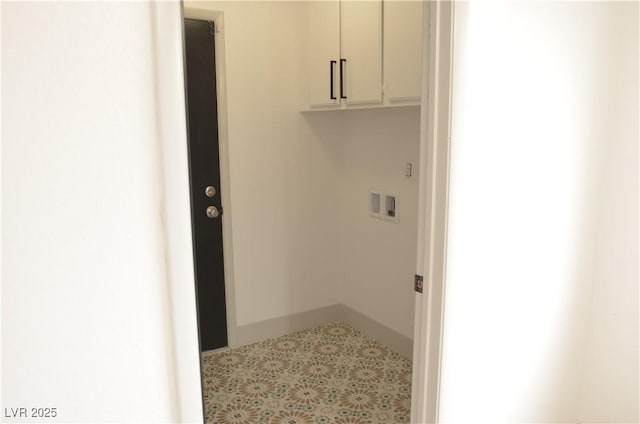 clothes washing area with hookup for a washing machine, cabinet space, and baseboards